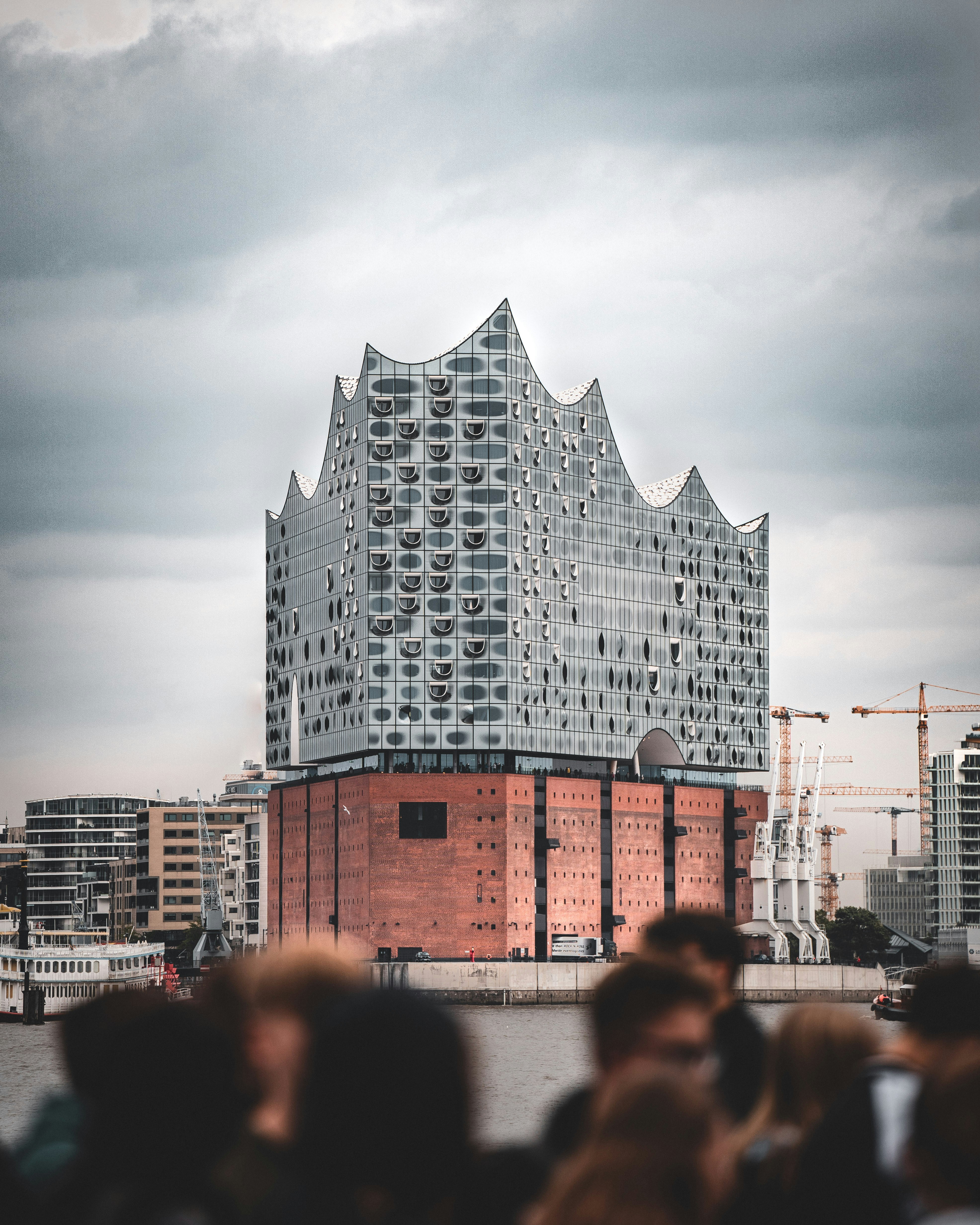 uma multidão de pessoas em pé na frente de um edifício alto