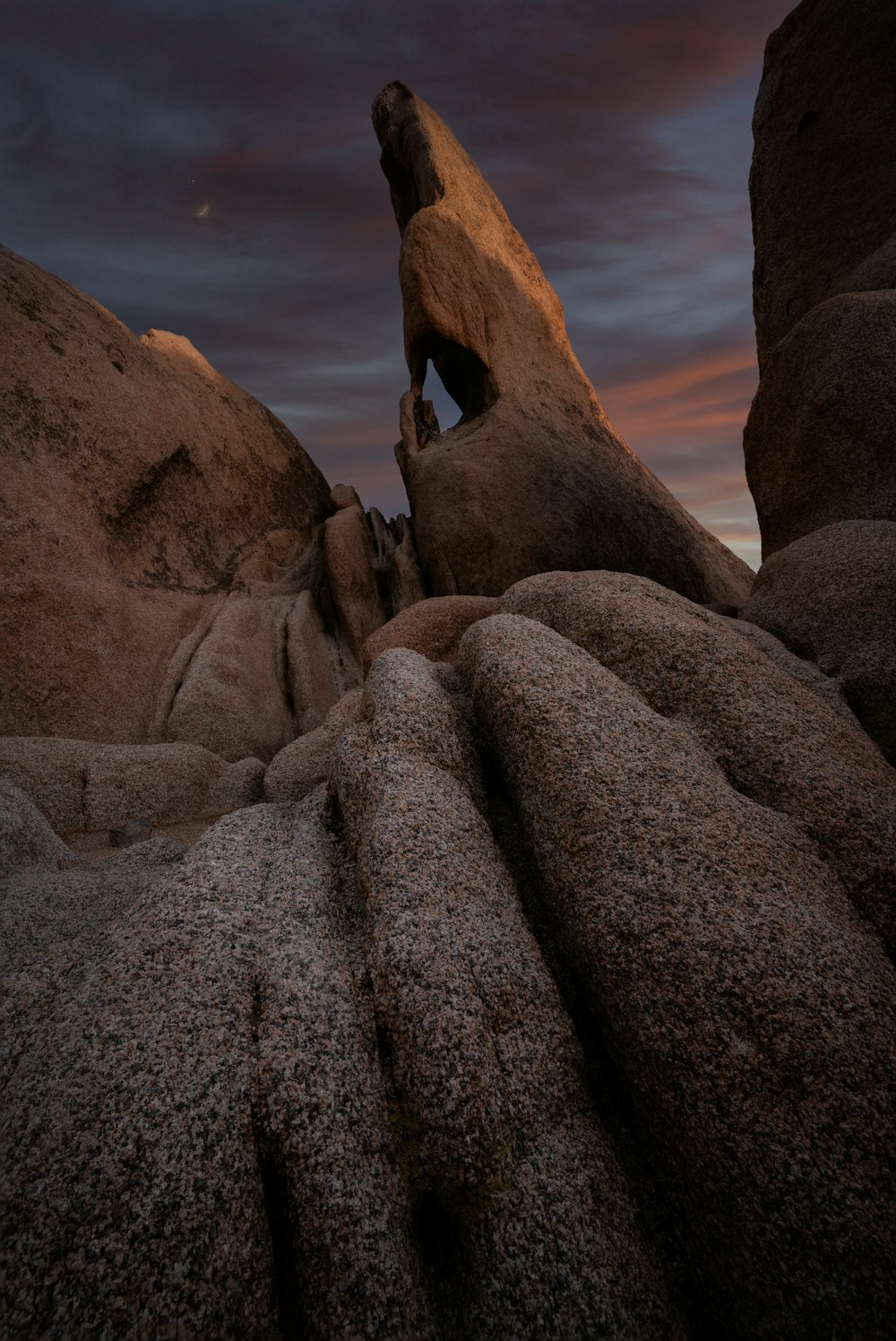 a person climbing up a rock formation at night