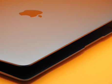 Close-up of a MacBook being carefully opened for screen replacement by a skilled technician.
