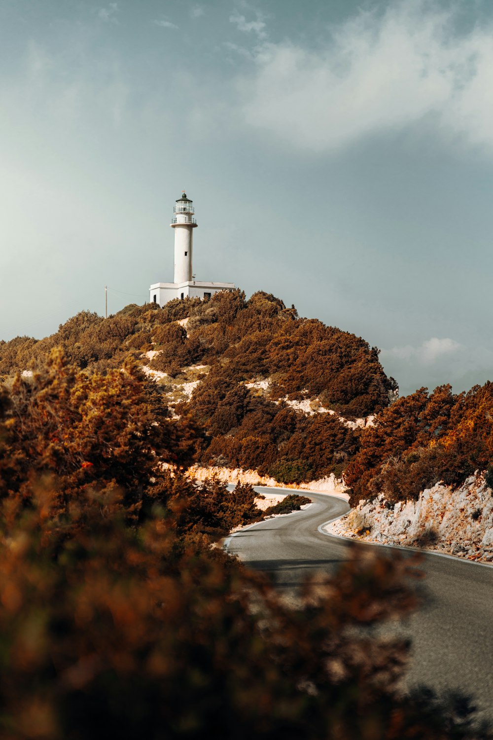 a white light house on top of a hill