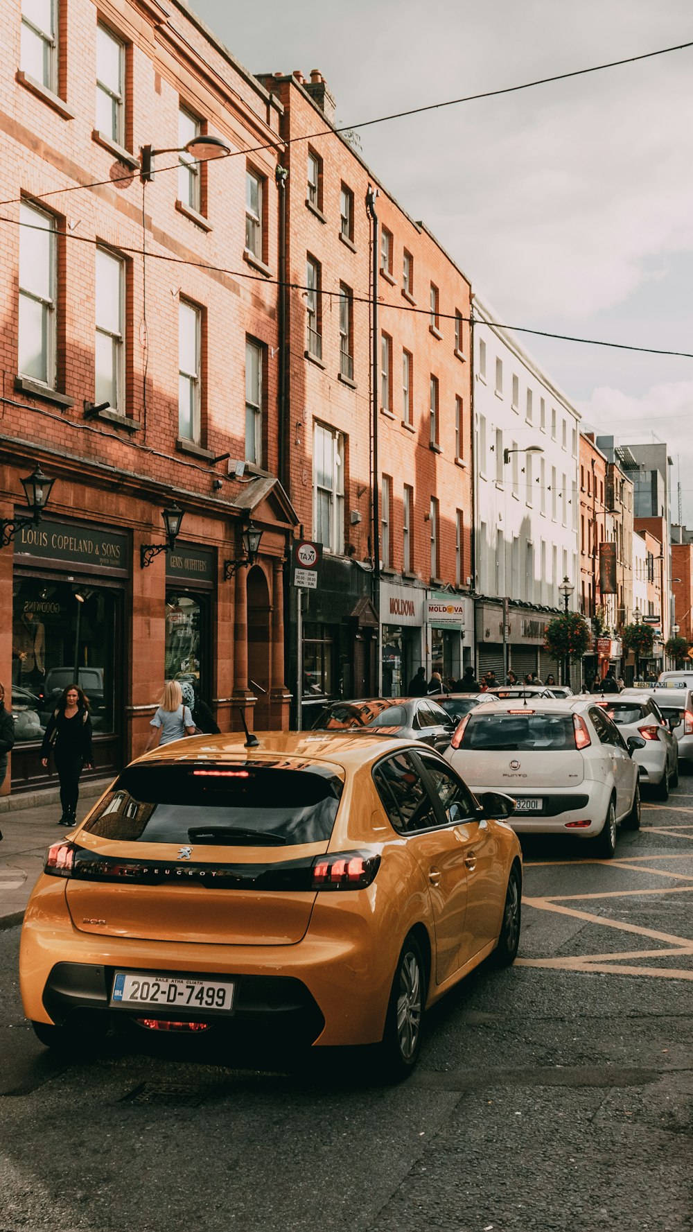 a city street filled with lots of traffic next to tall buildings