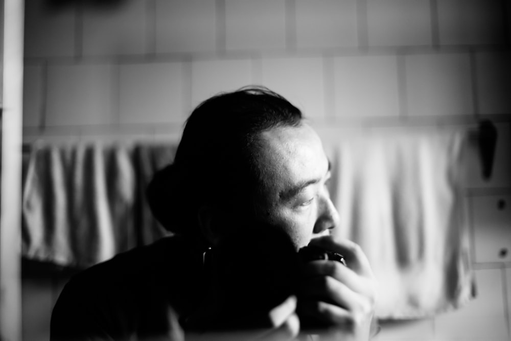 a black and white photo of a man brushing his teeth