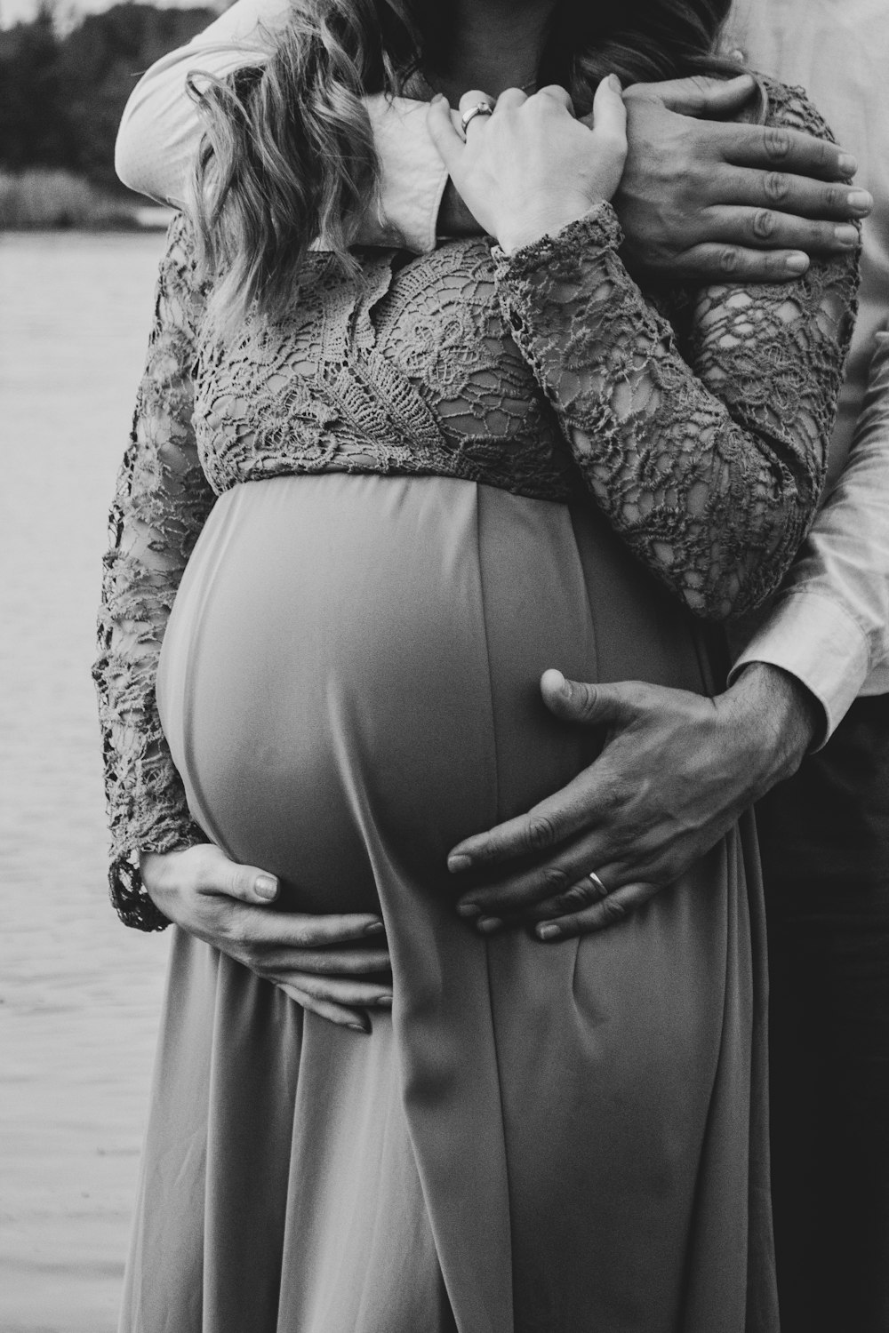 uma mulher grávida está segurando a barriga de seu marido