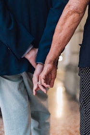 a close up of two people holding hands