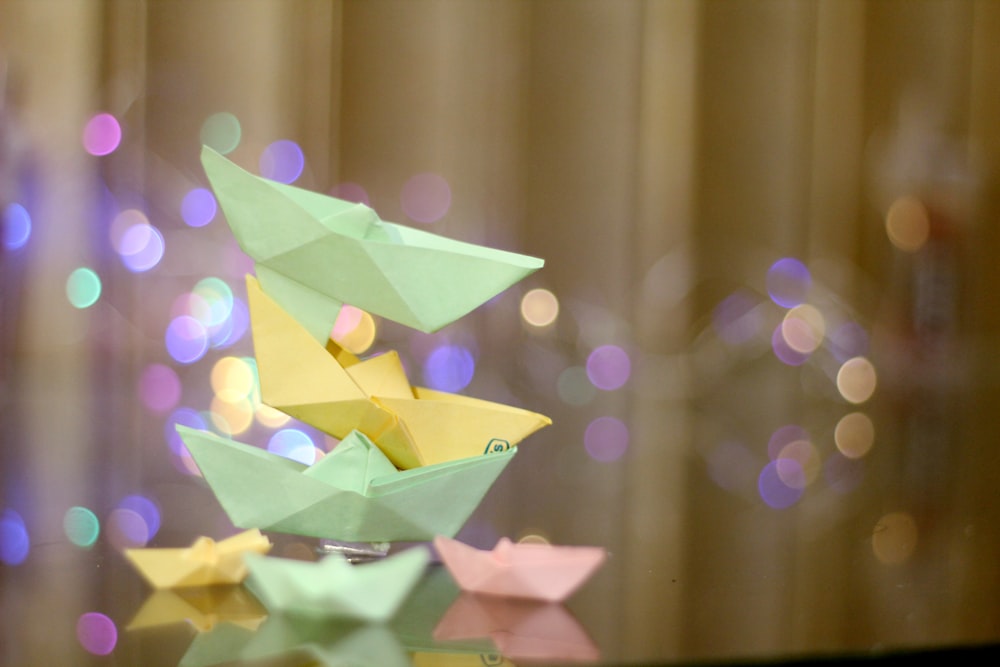 a glass table topped with origami boats on top of it