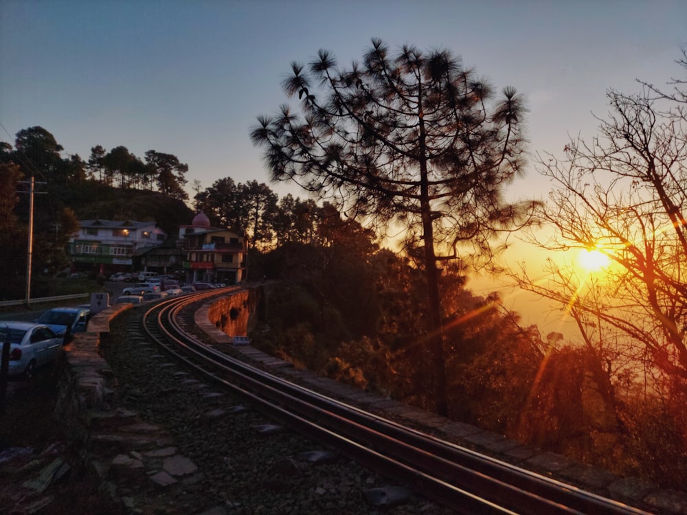 the sun is setting over a train track