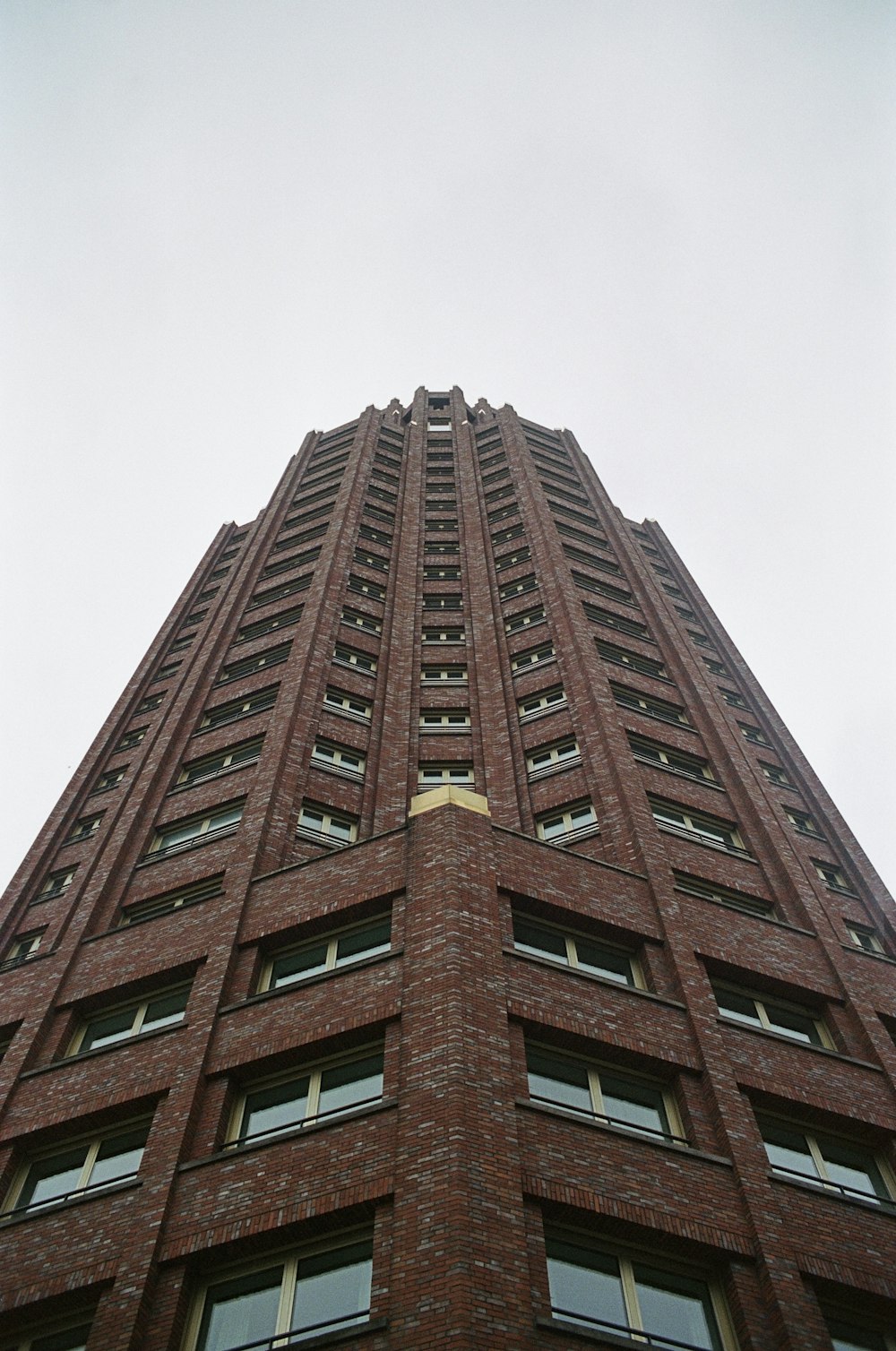 a very tall brick building with a clock on it's side