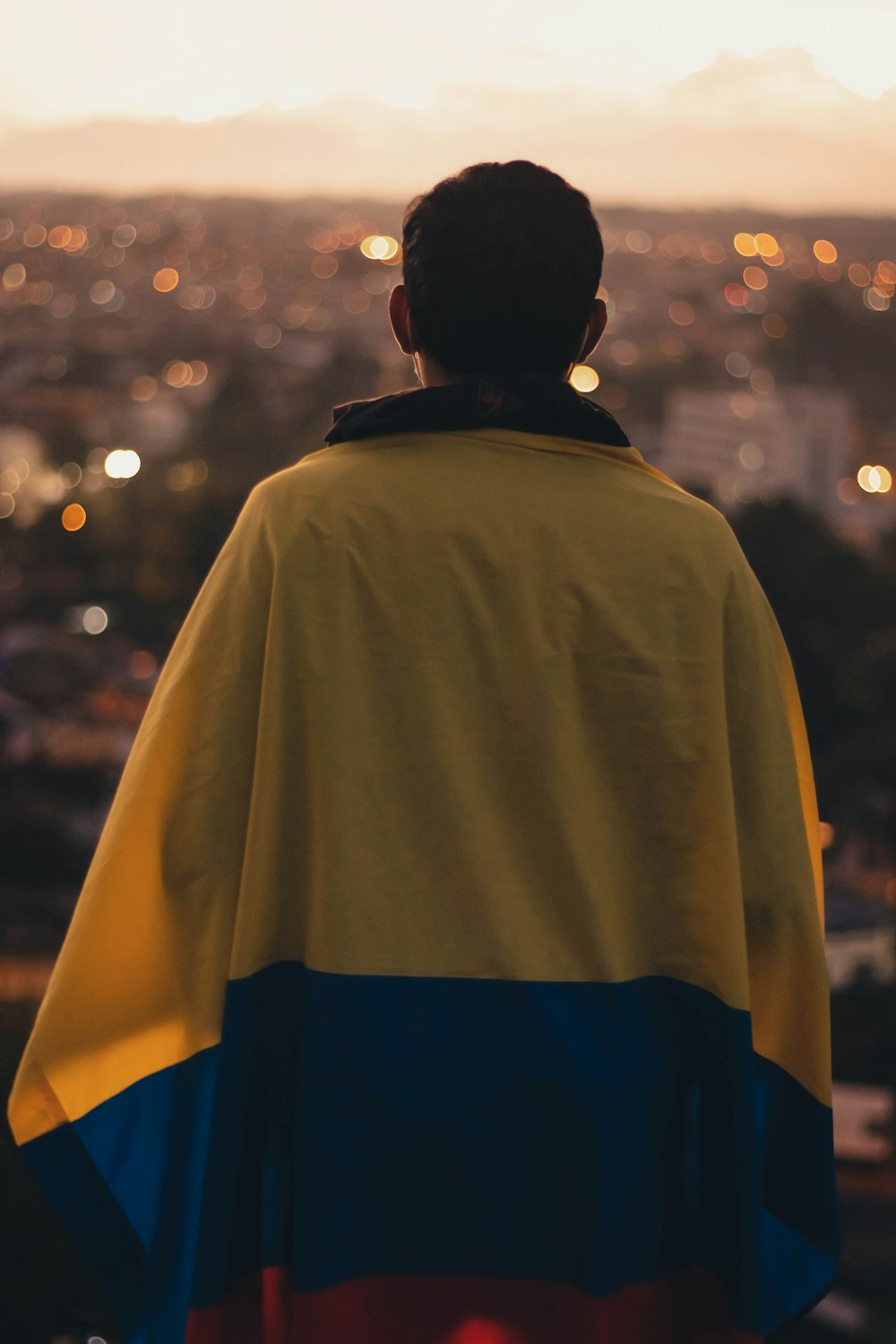 a man in a cape looking out over a city