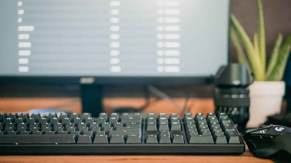 a computer keyboard sitting on top of a wooden desk