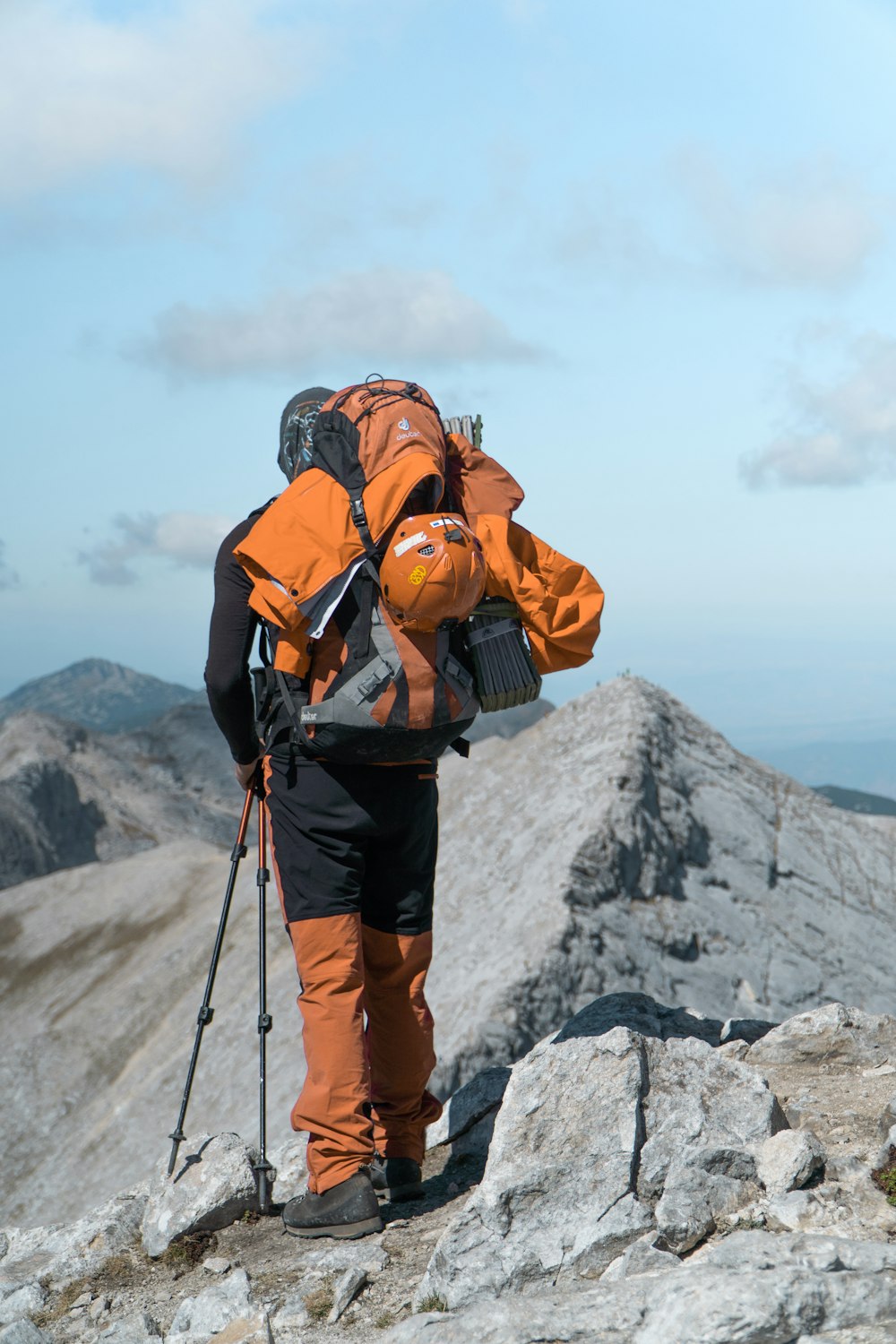 a man with a backpack and skis on top of a mountain