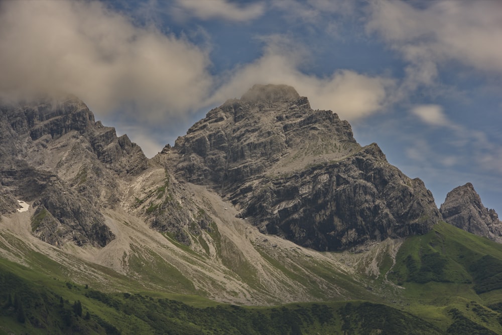 a mountain range with a few clouds in the sky