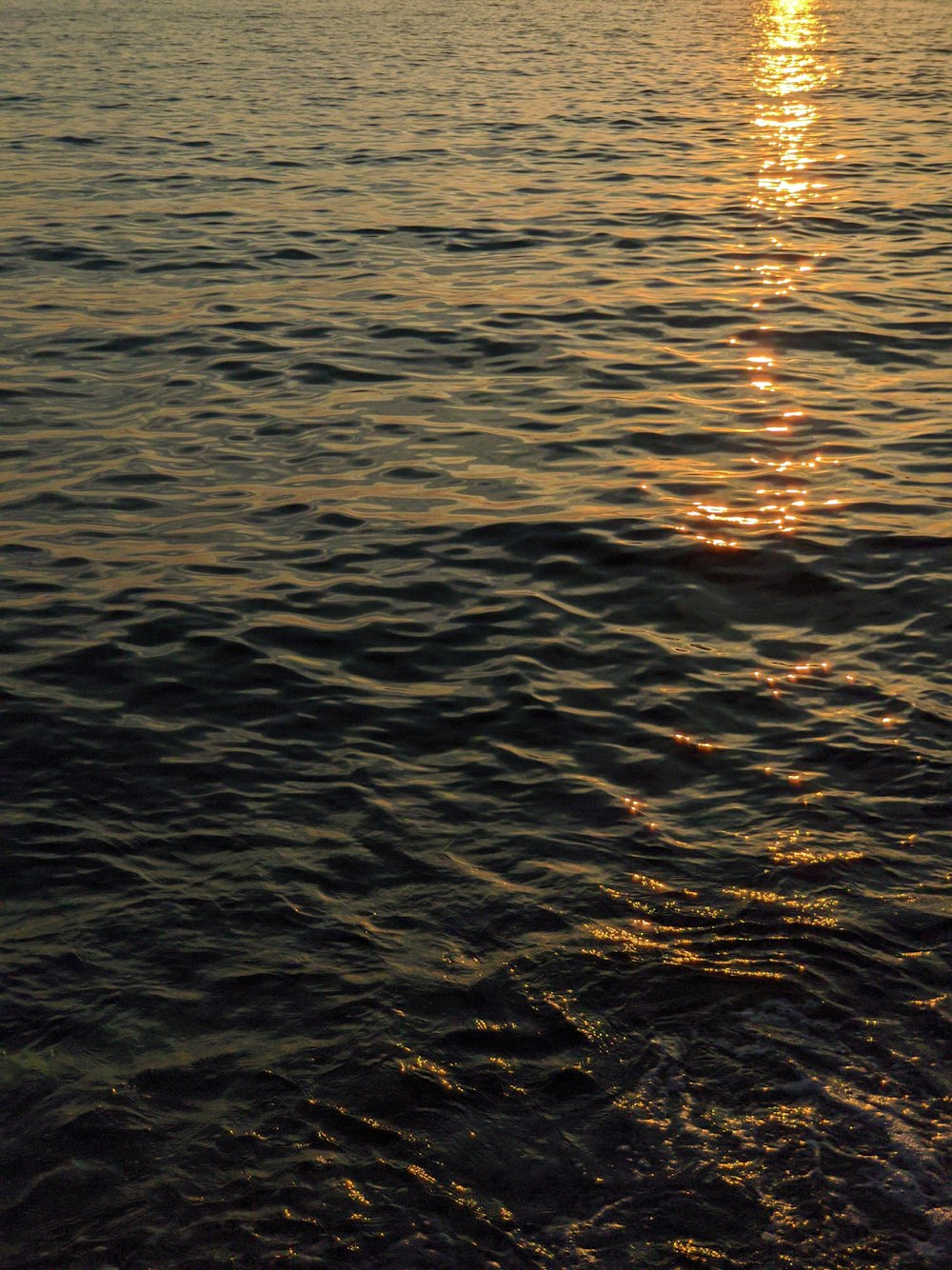 a large body of water with a boat in the distance