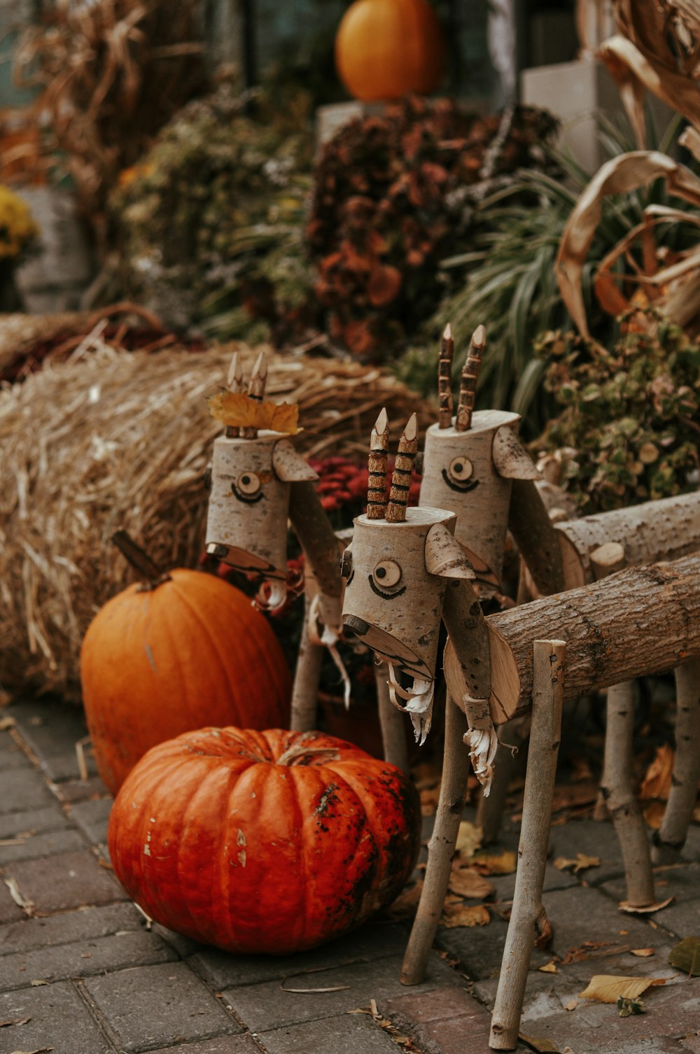 a couple of wooden horses standing next to a pumpkin