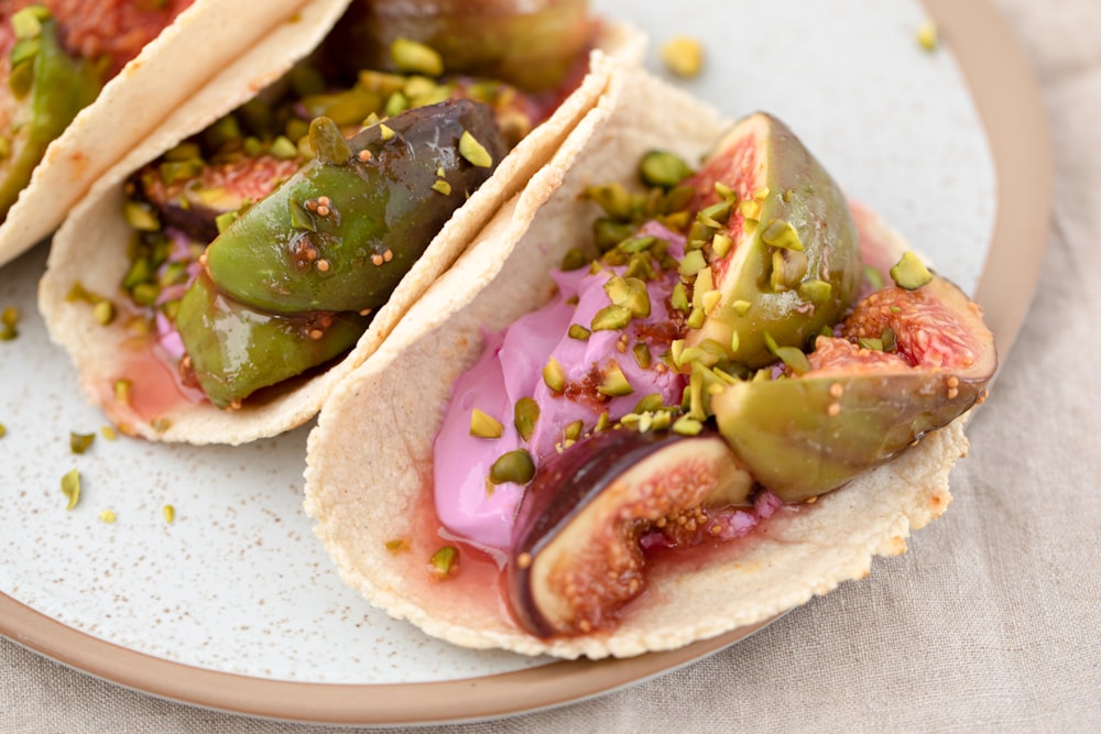 three tacos with different toppings on a plate