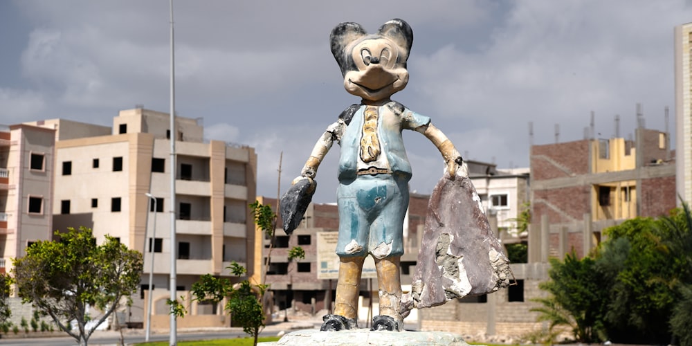 a statue of a mouse holding a bag