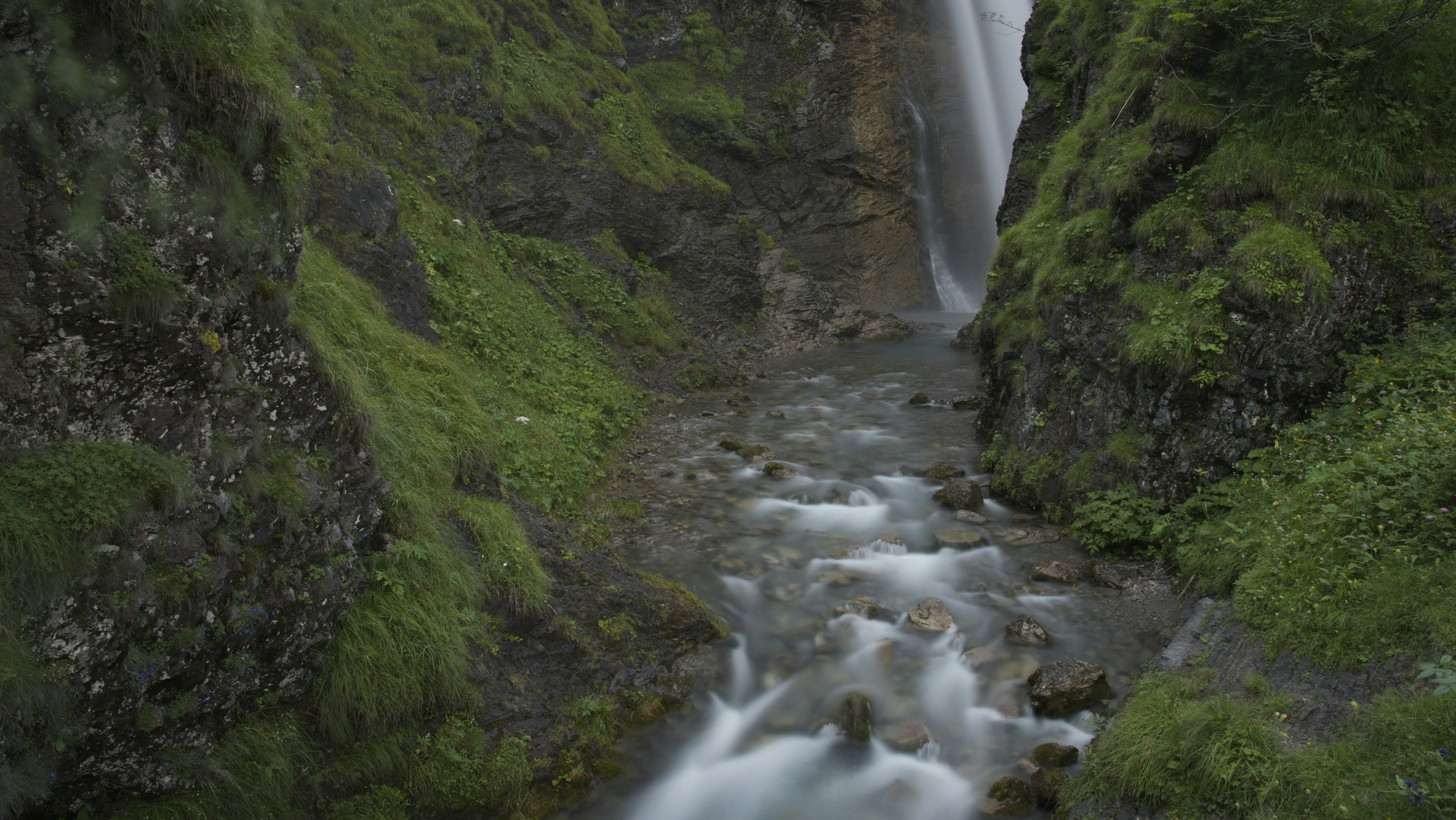a small waterfall in the middle of a forest