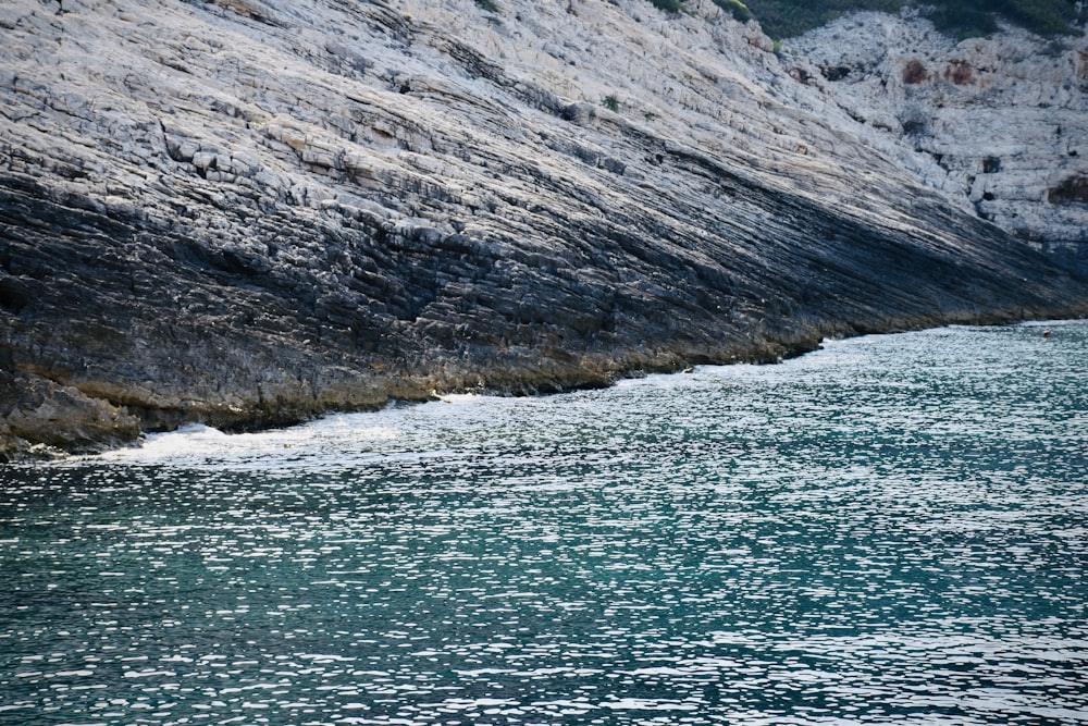 um corpo de água perto de um penhasco rochoso
