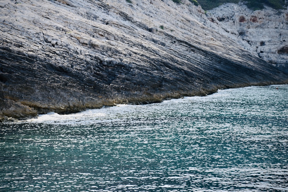 a body of water near a rocky cliff