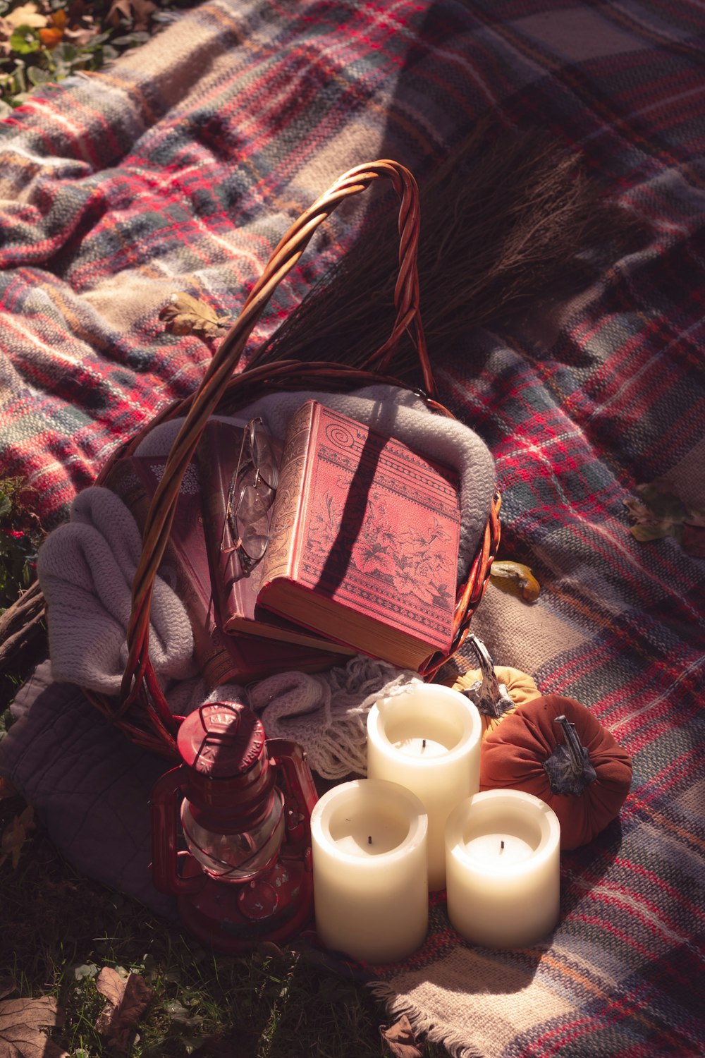 a basket filled with candles and books on top of a blanket