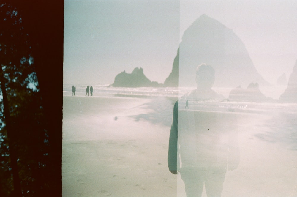 a man standing on a beach next to the ocean