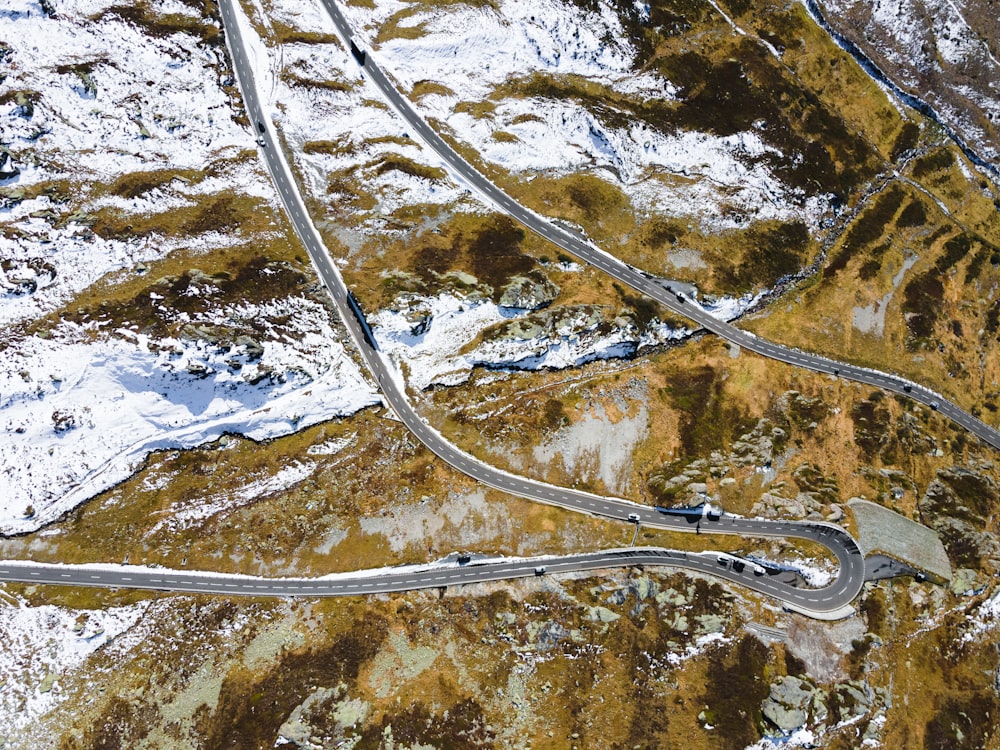 an aerial view of a winding road in the mountains