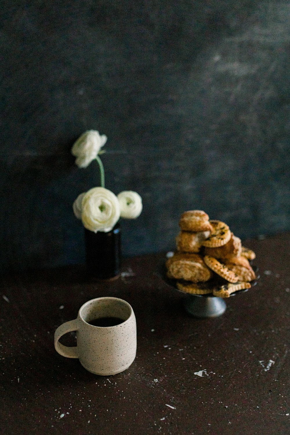 a cup of coffee and some cookies on a table