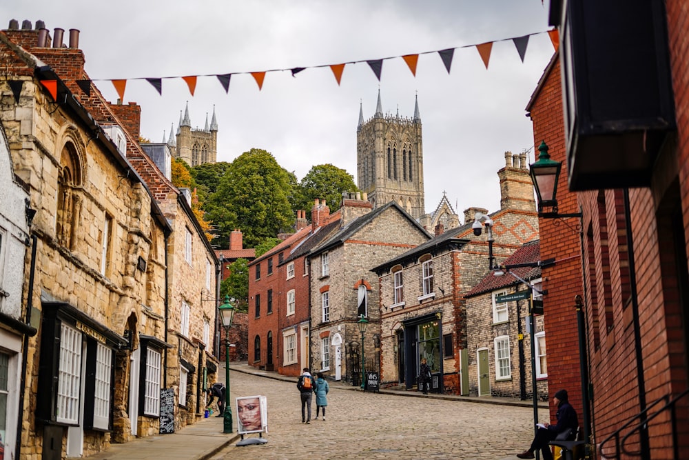 a cobblestone street with people walking on it