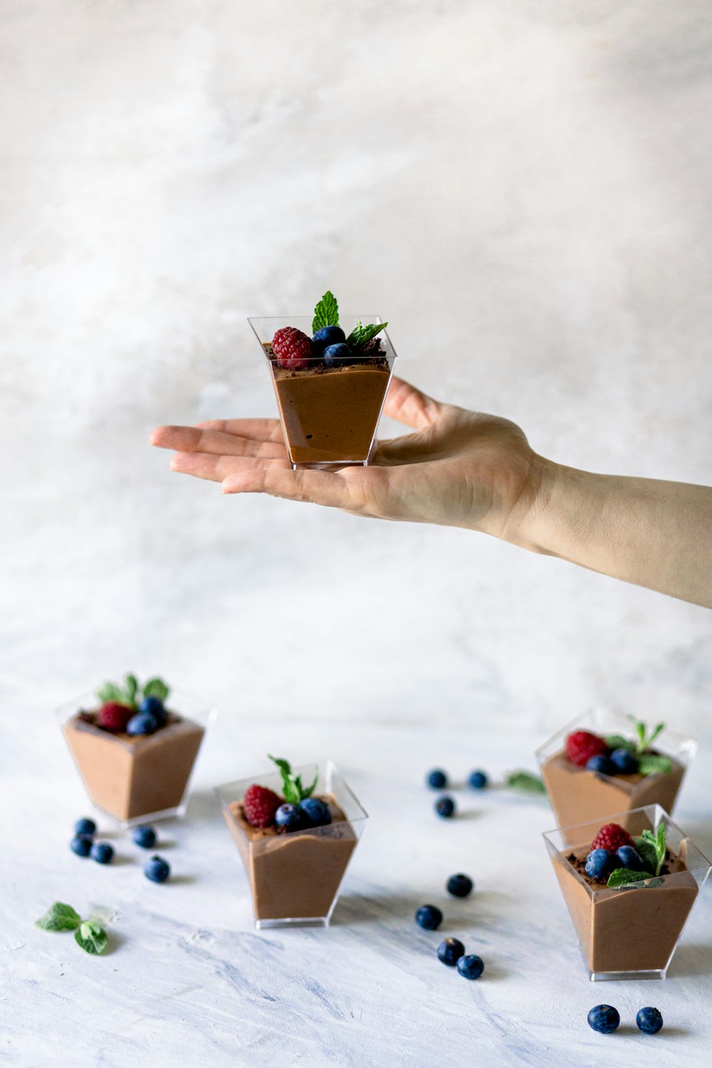 a person holding a small dessert in their hand