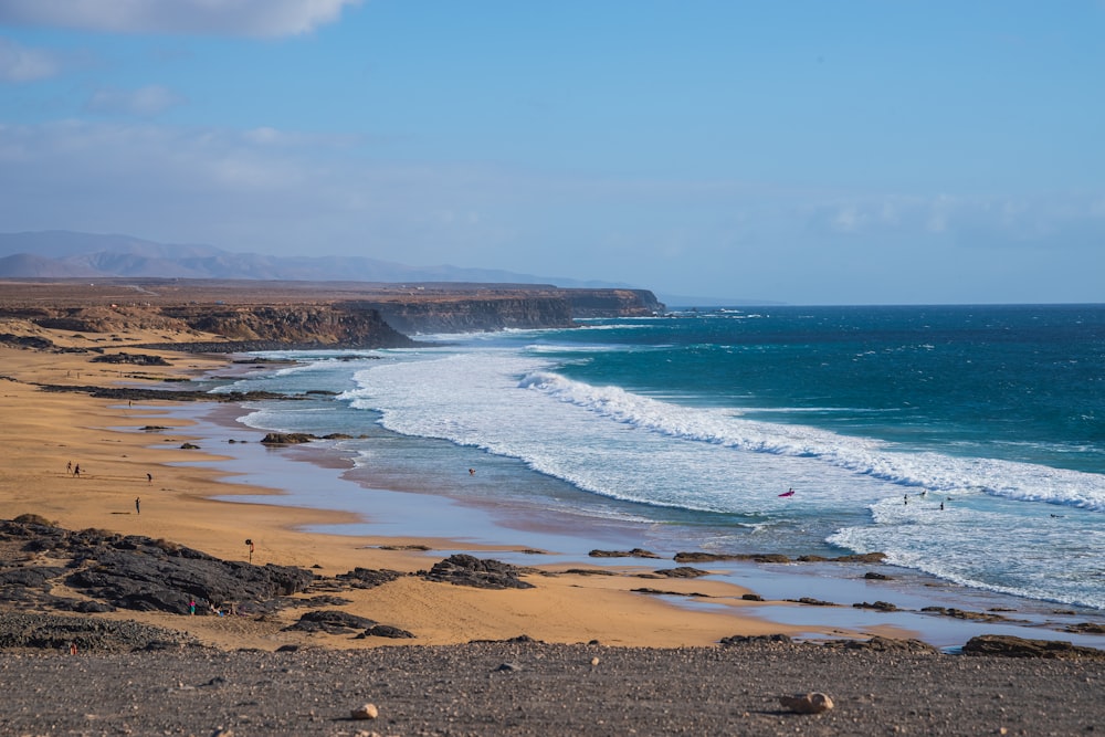 a view of a beach with people walking on it