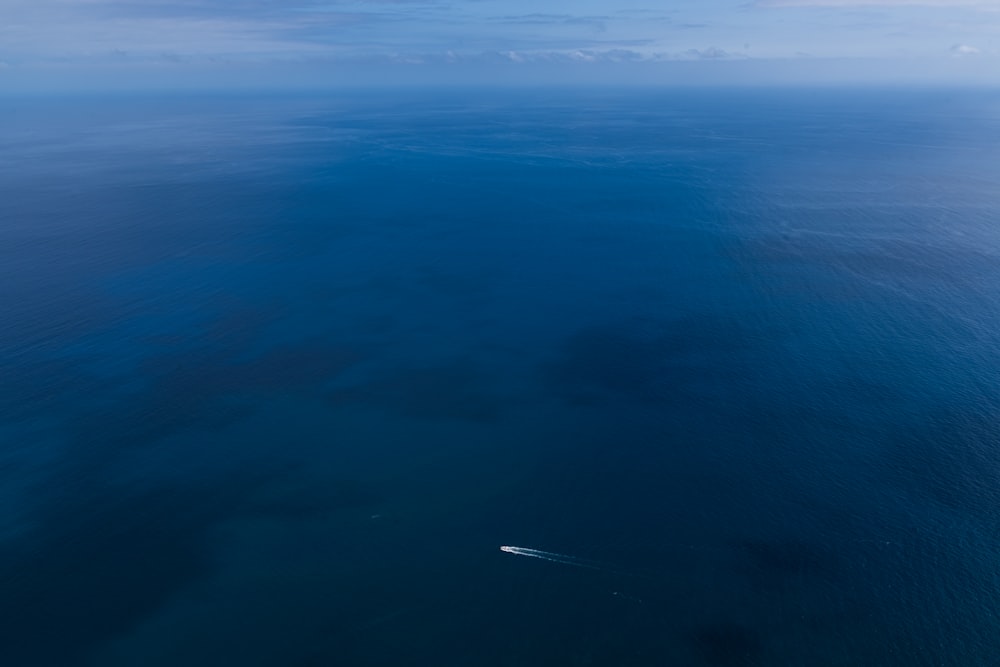 um avião voando sobre o oceano em um dia nublado