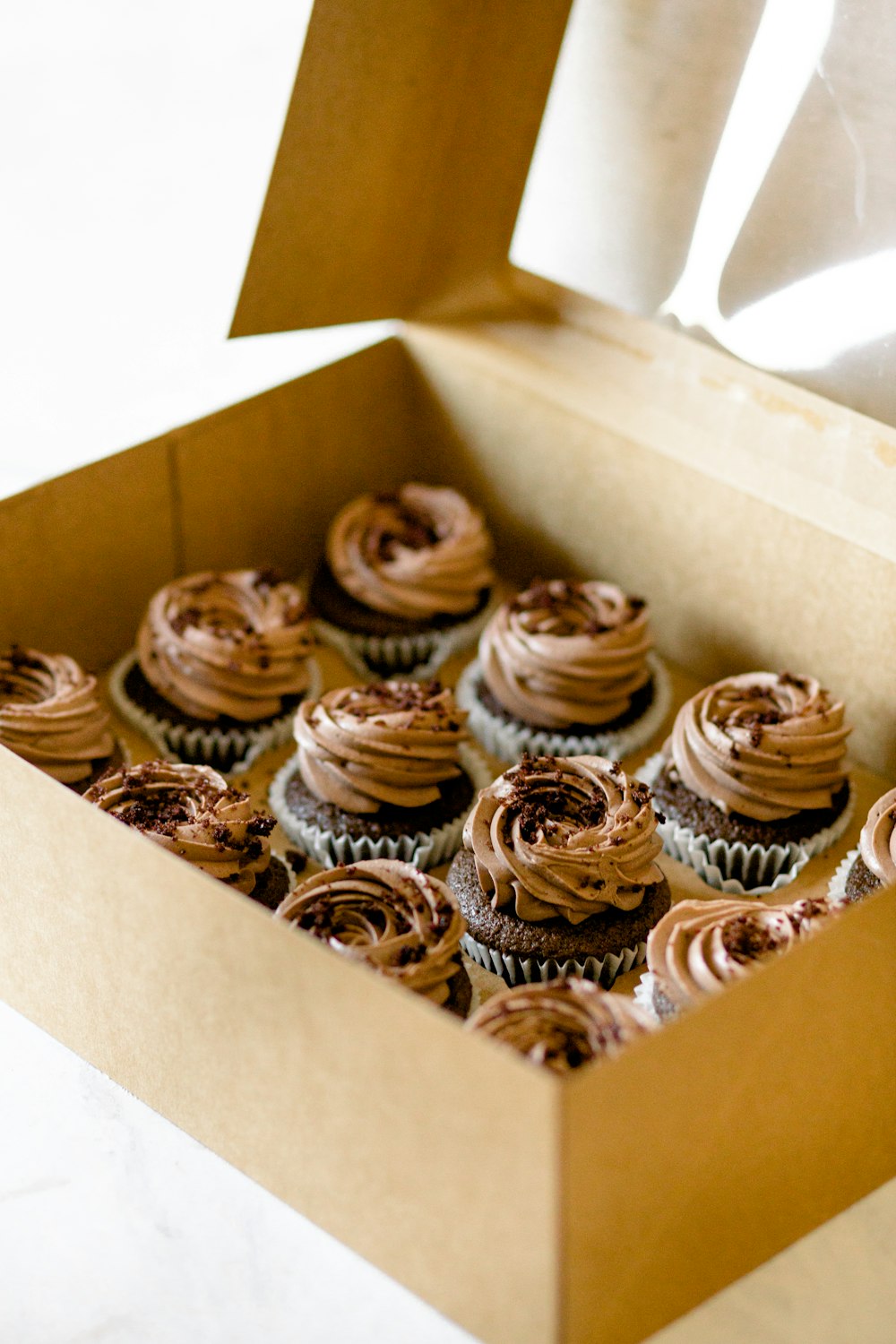 a box filled with chocolate cupcakes on top of a table
