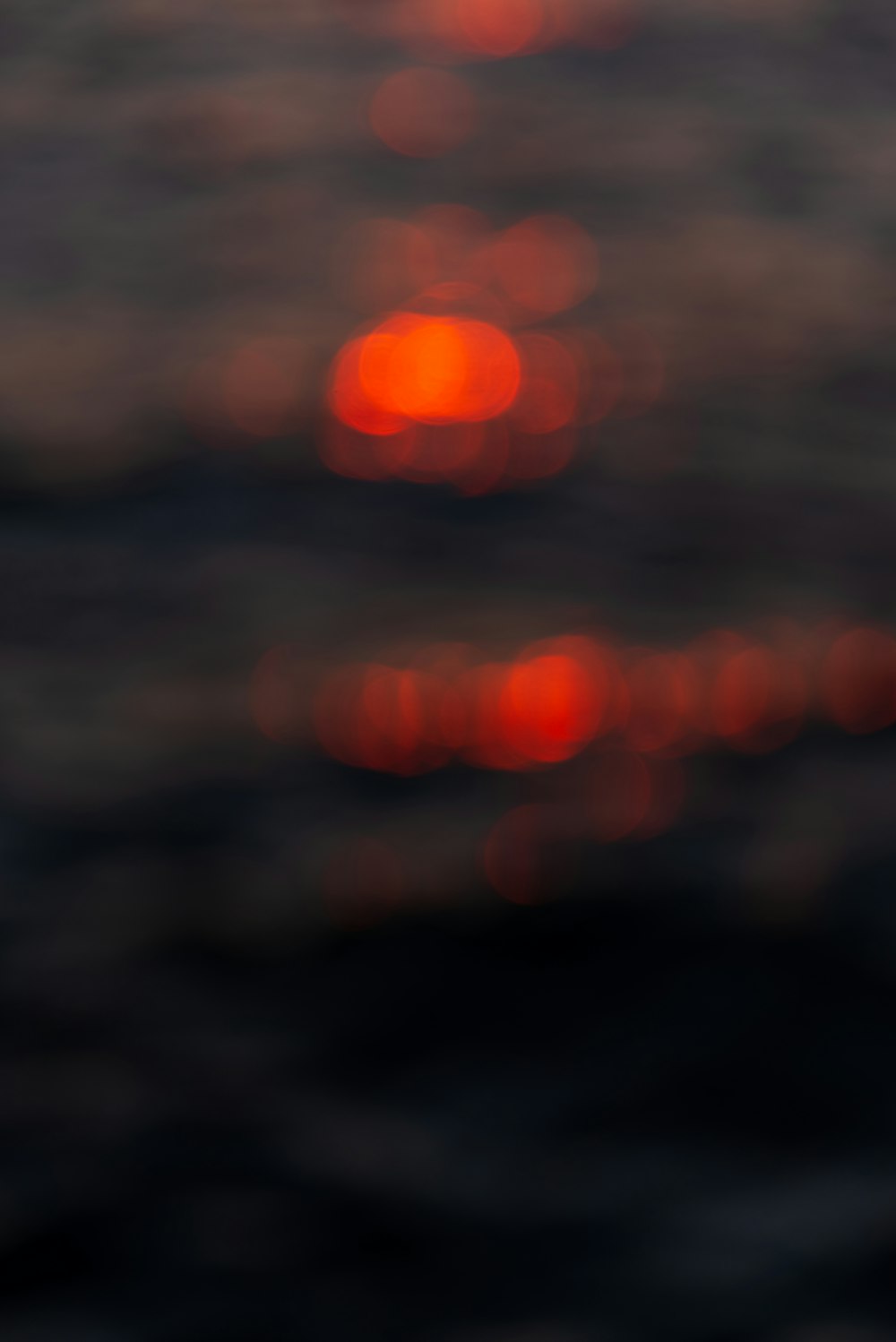 uma foto borrada do sol se pondo sobre o oceano