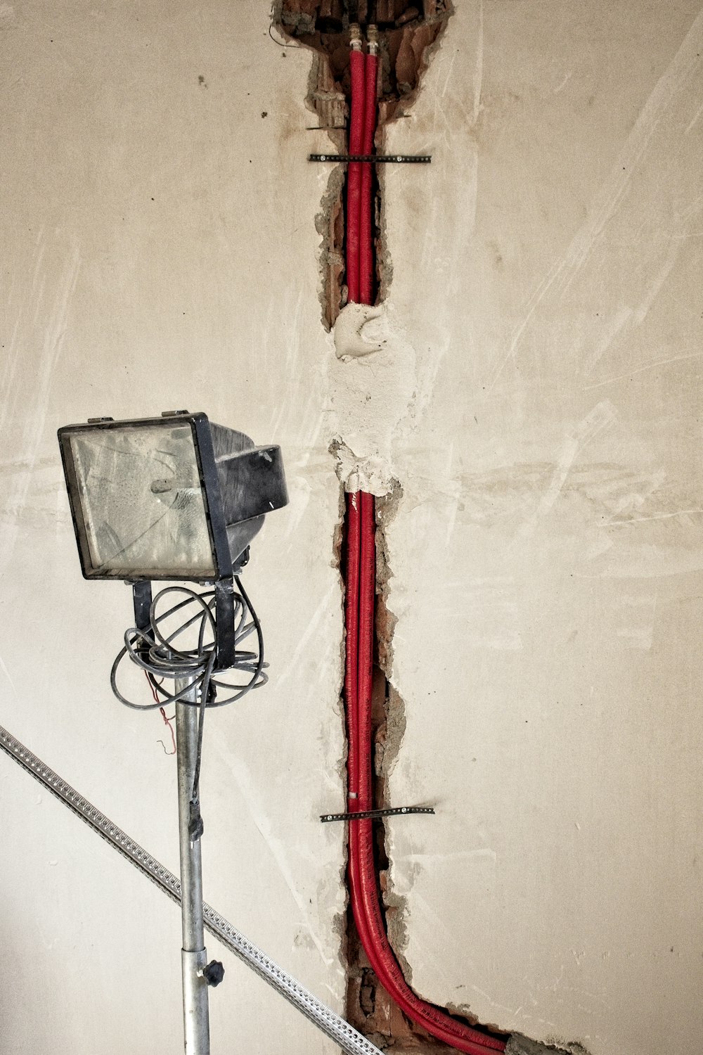 a red hose is connected to a white wall