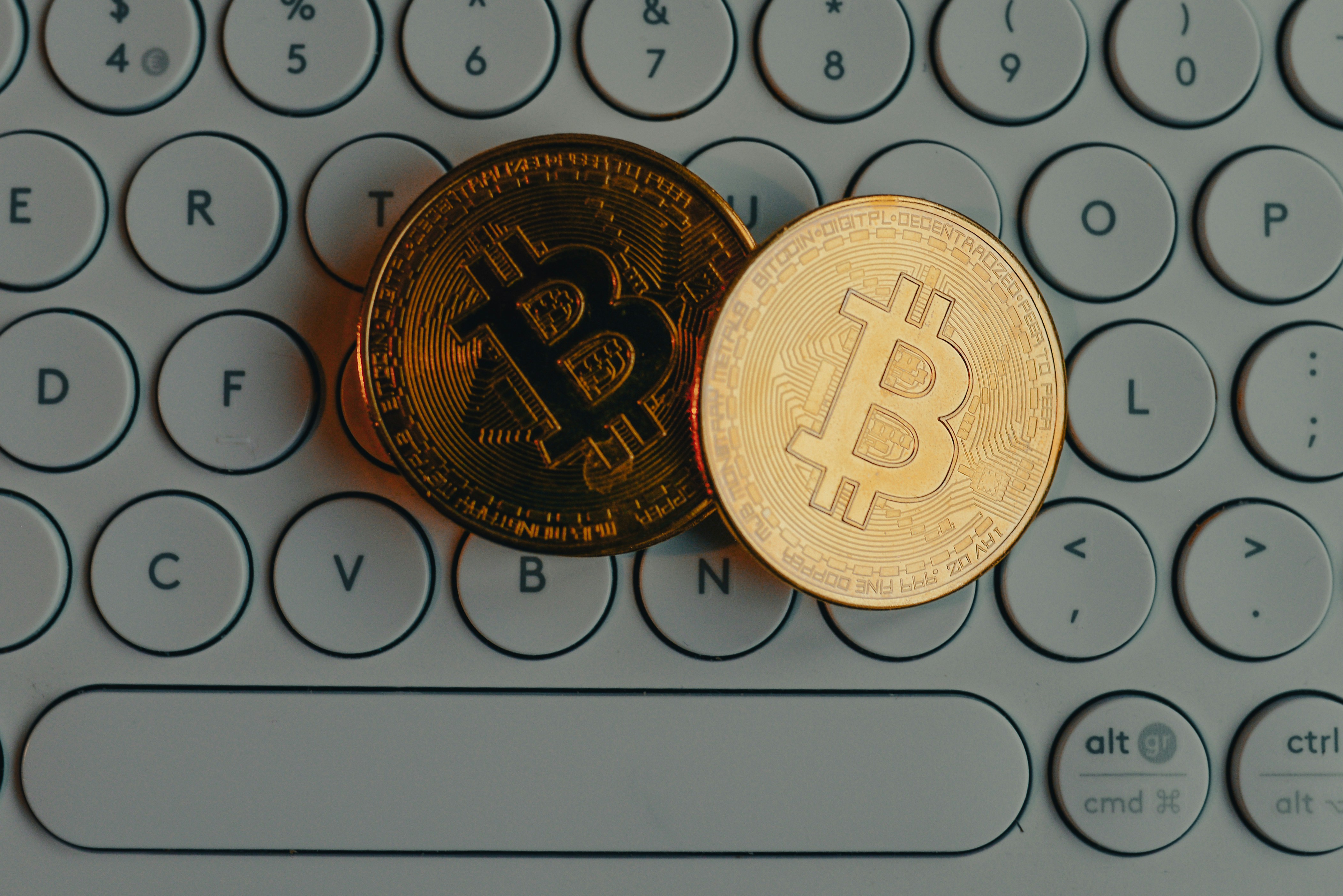 a bit coin sitting on top of a computer keyboard - 配图