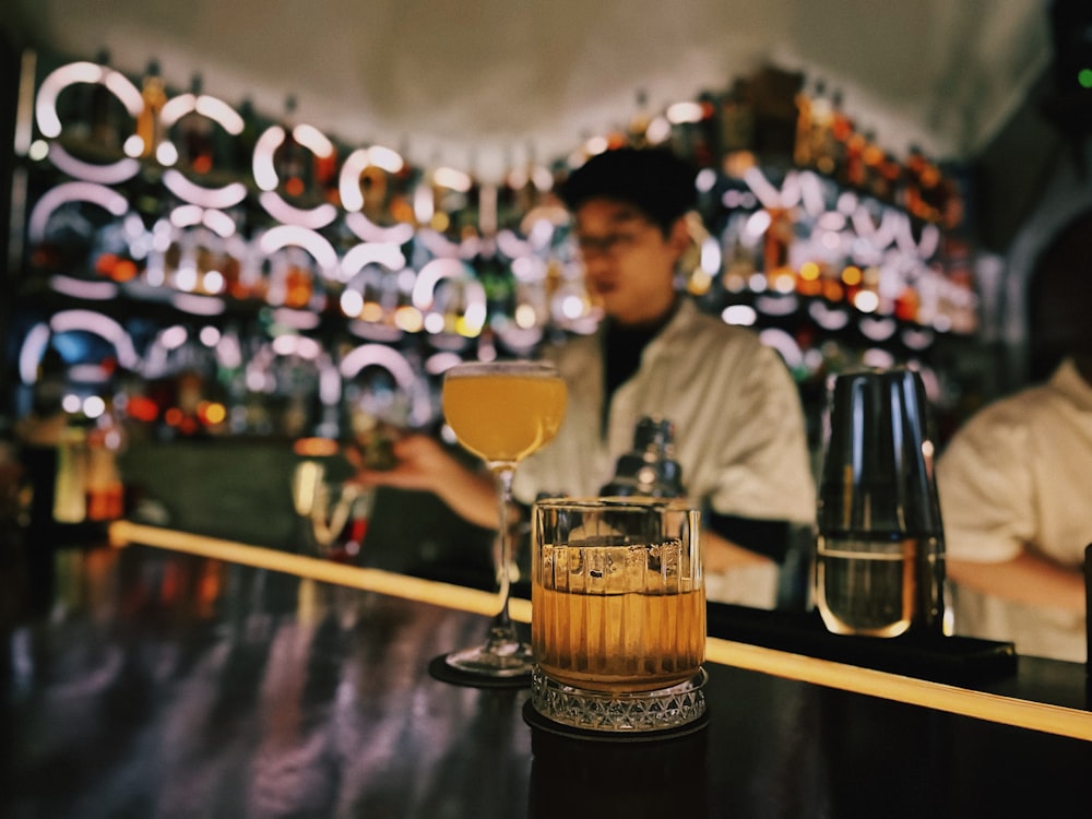 a man sitting at a bar with a drink in front of him