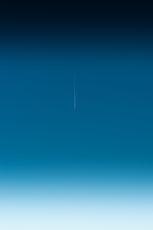 an airplane is flying in the blue sky