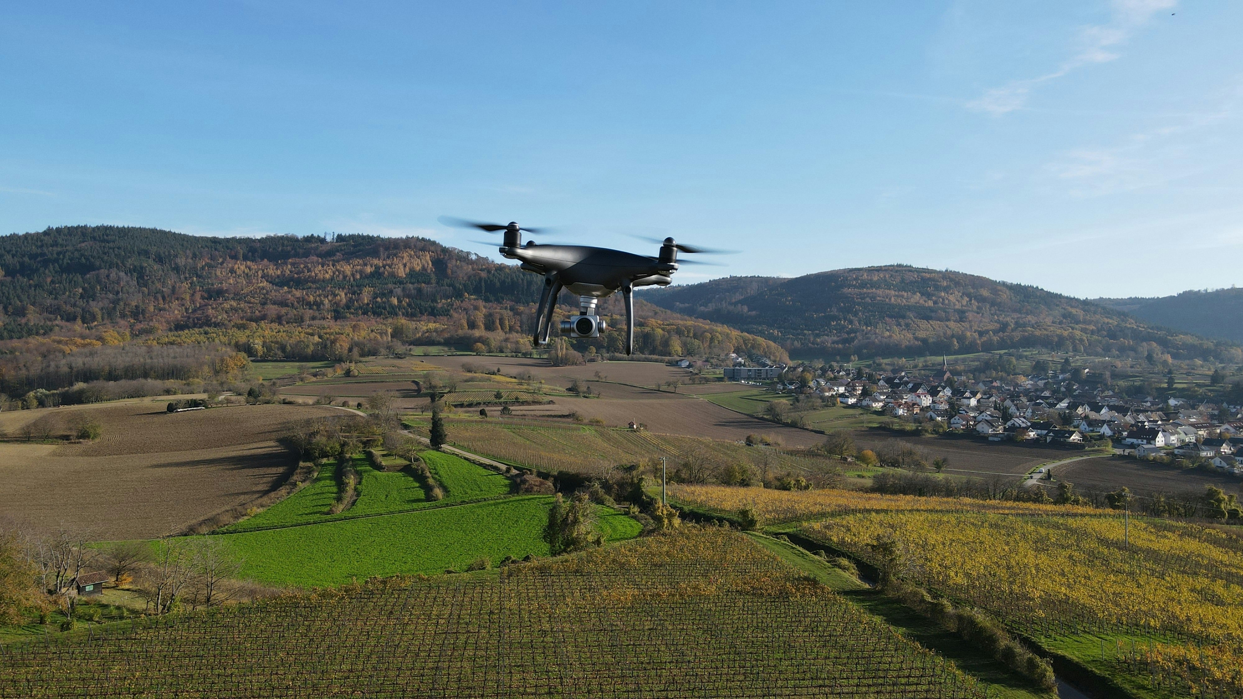 a small plane flying over a lush green hillside