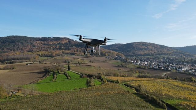 a small plane flying over a lush green hillside