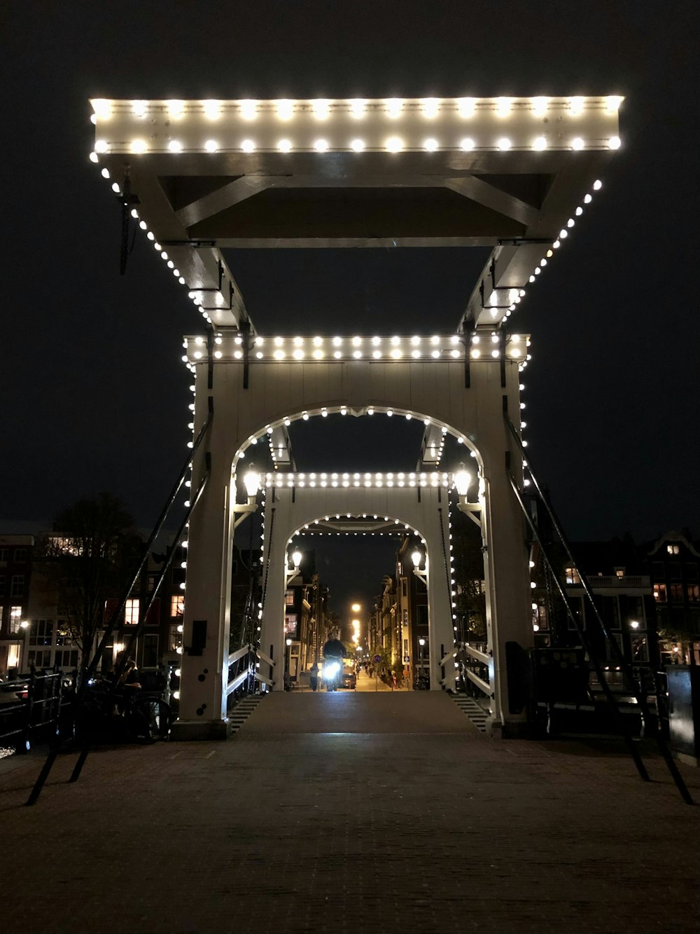 a white bridge with lights on it at night