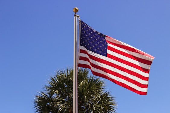a large american flag flying in the wind