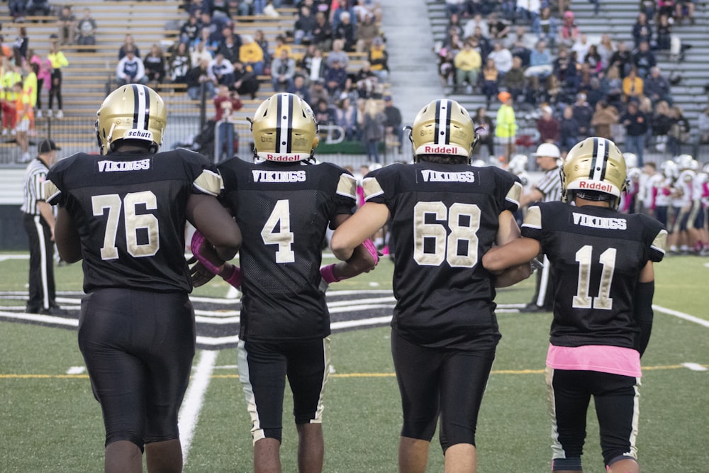 a group of football players standing on top of a field