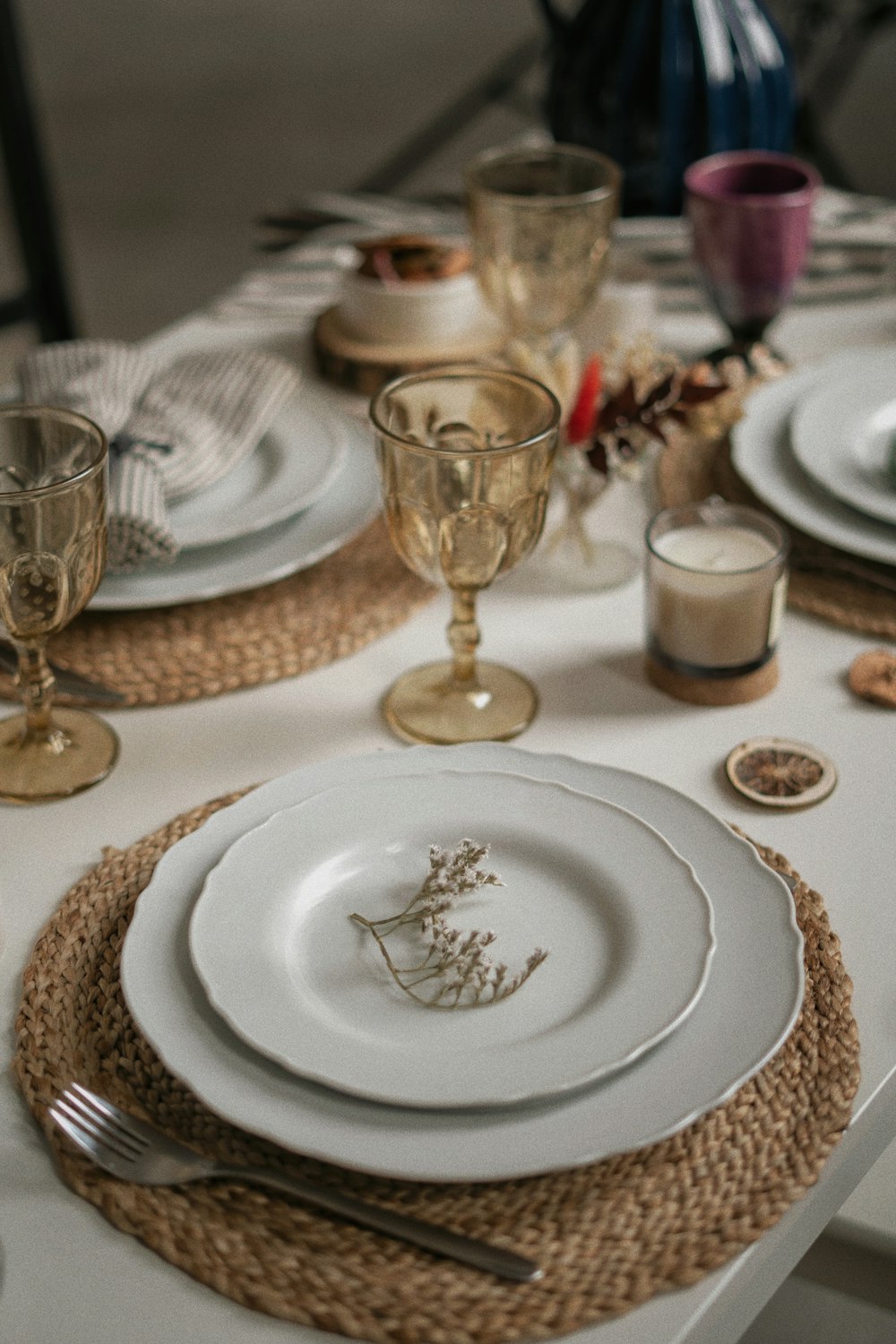 Una mesa preparada para una cena formal con ajustes de lugar