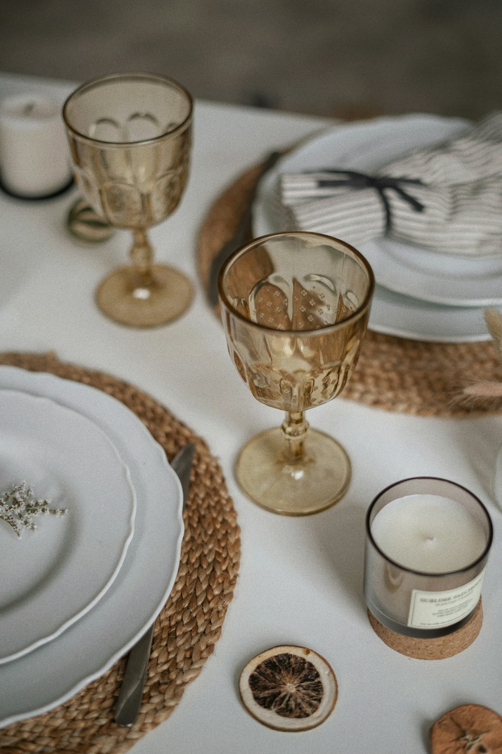 a white table topped with plates and glasses