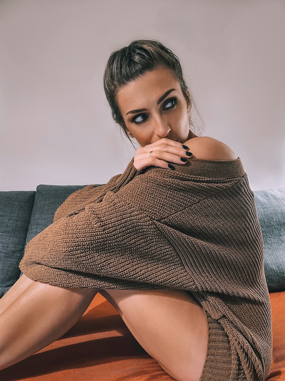 a woman sitting on top of a couch covered in a blanket