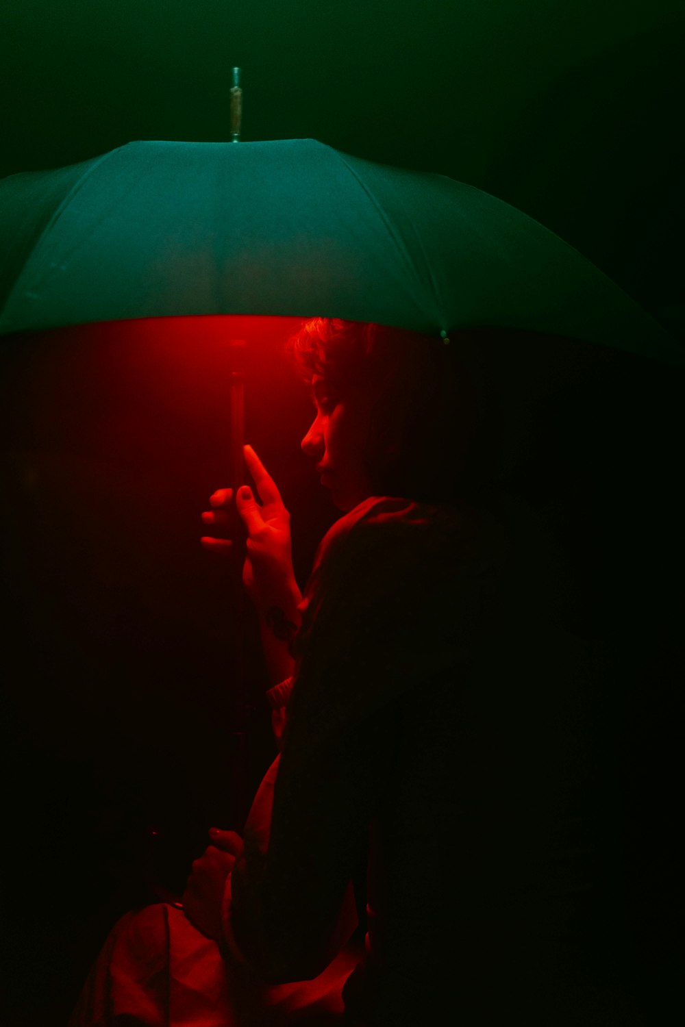 Un uomo che tiene un ombrello nel buio