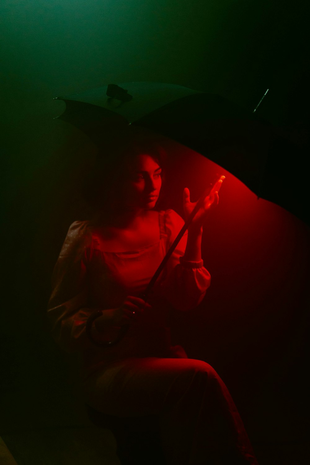 a woman holding an umbrella in a dark room