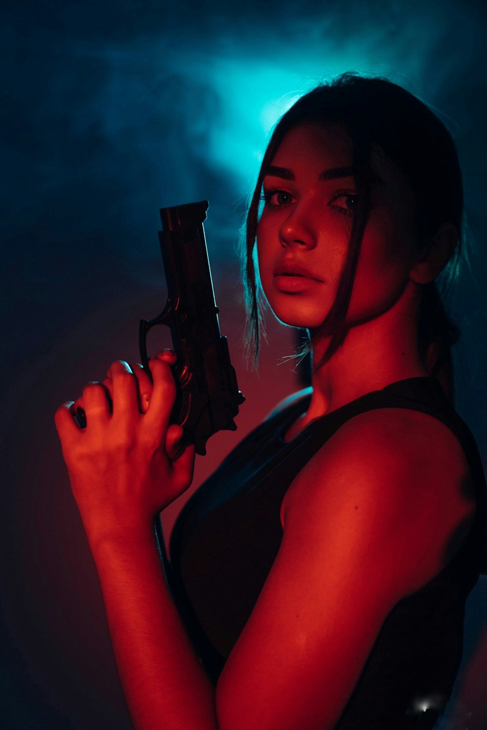 a woman holding a gun in a dark room