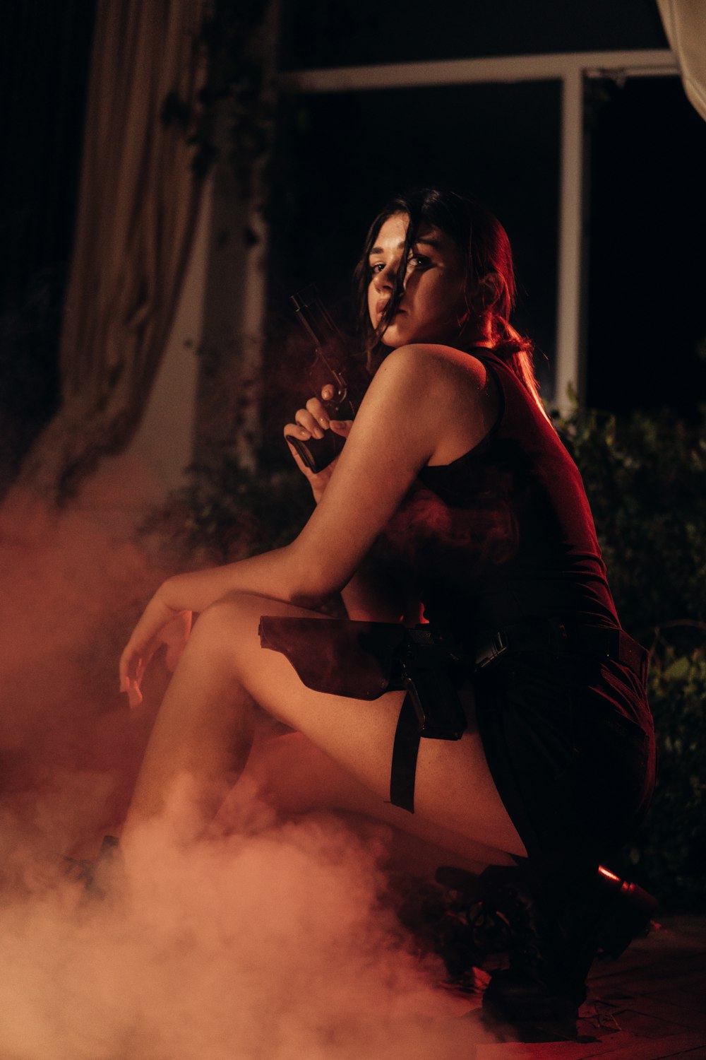 a woman in a red dress is smoking a cigarette