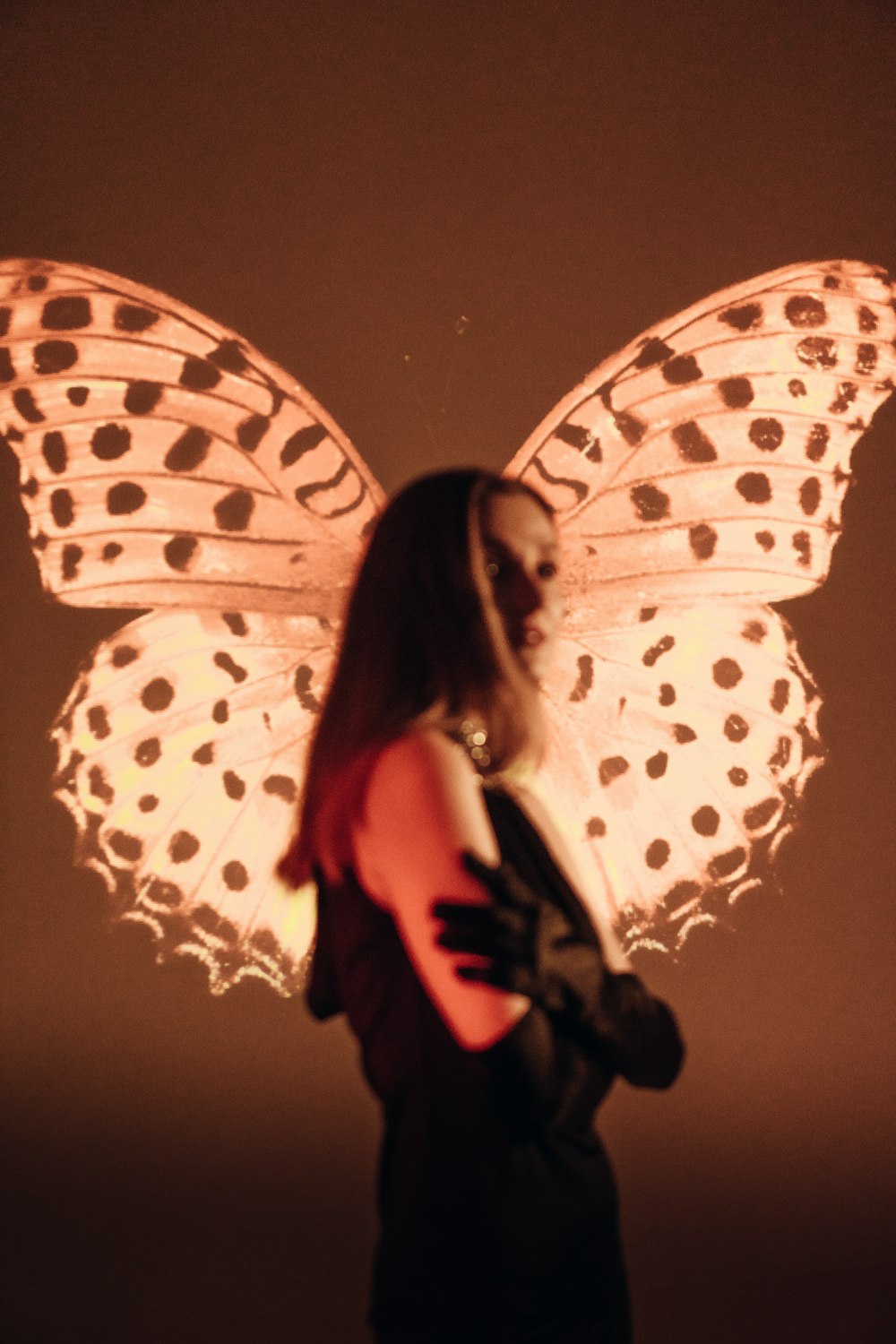 a woman in a black dress with a butterfly on her back