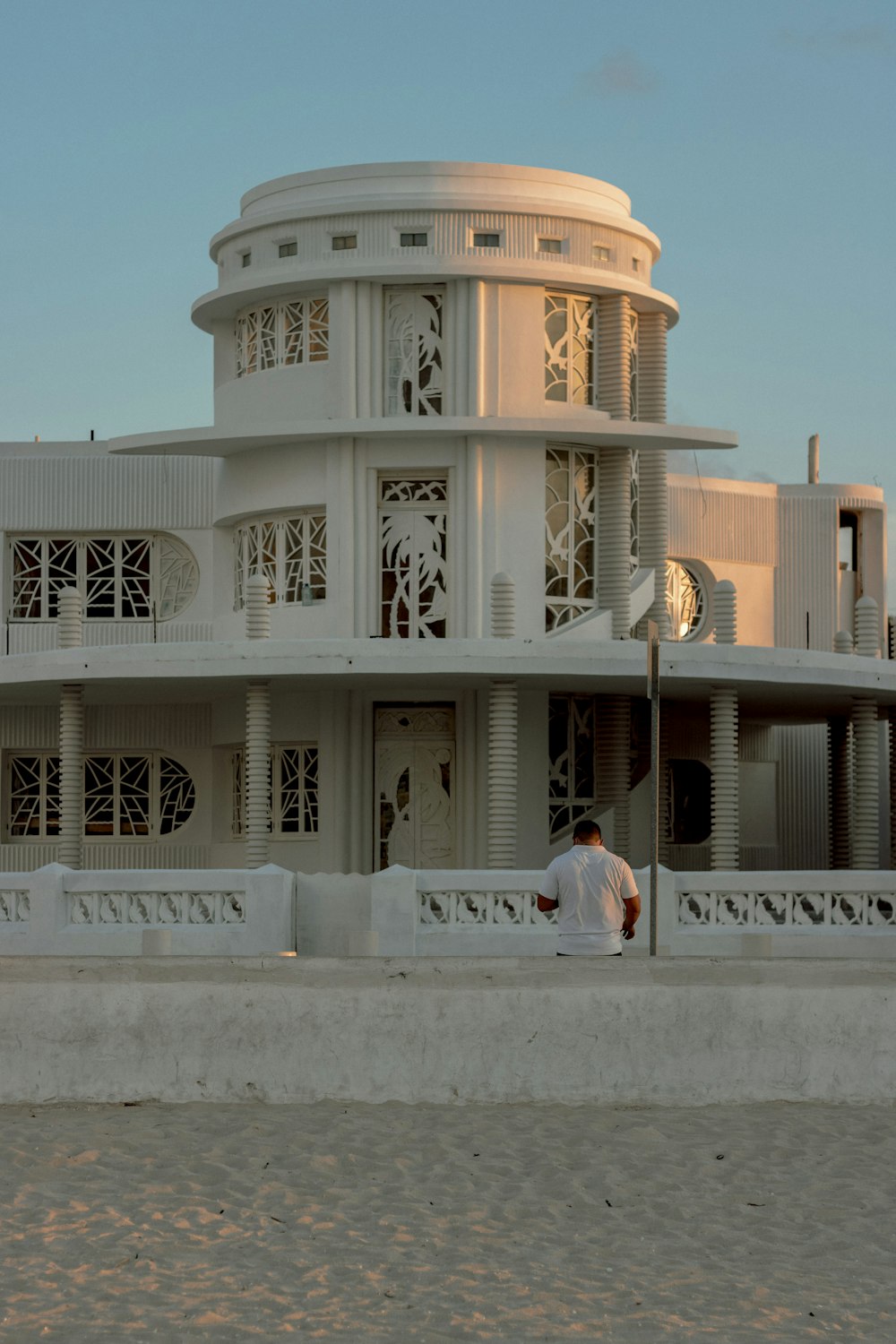 a man sitting on a ledge in front of a building